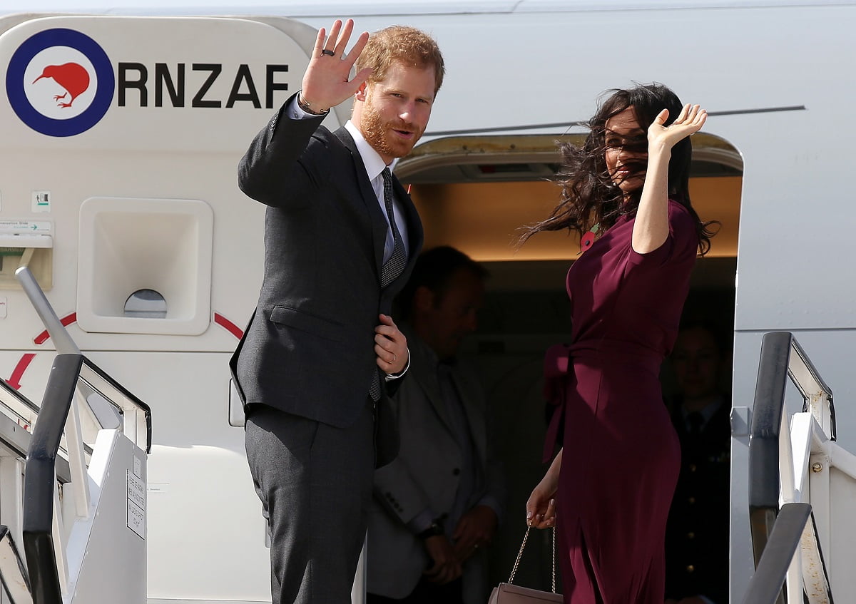 Britain's Prince Harry and his wife Meghan, Duchess of Sussex wave as they board an aeroplane at the airport in Sydney on October 28, 2018. - Prince Harry and his wife Meghan are travelling to New Zealand to continue their tour of the South Pacific. (Photo by Rick Rycroft / POOL / AFP) (Photo credit should read RICK RYCROFT/AFP via Getty Images)