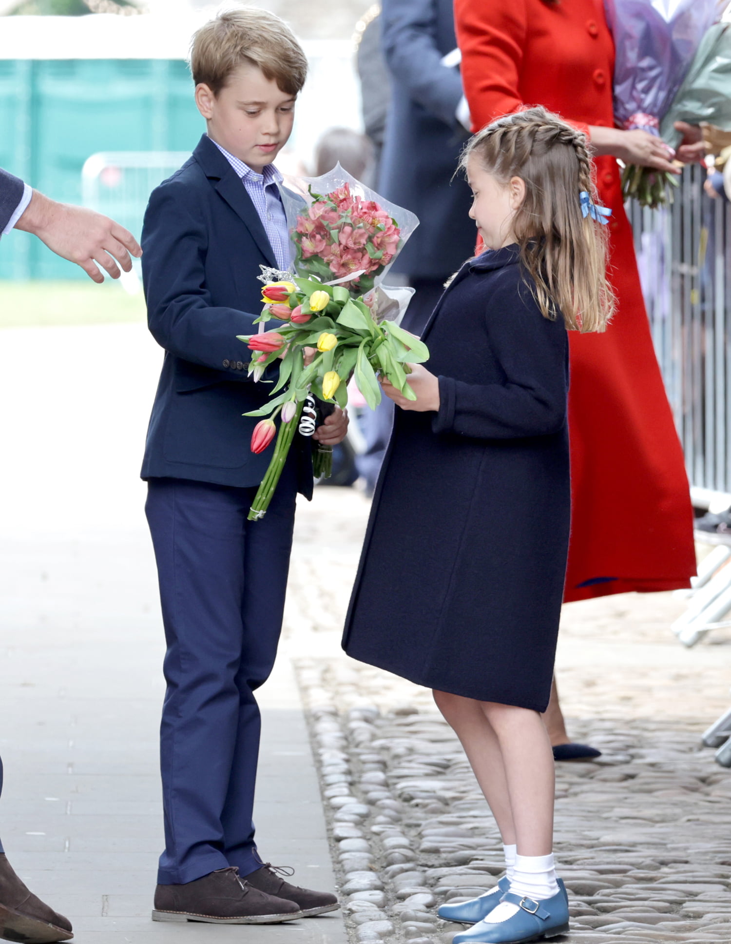 CARDIFF, WALES - JUNE 04: Prince George of Cambridge and Princess Charlotte of Cambridge hold gifts of flowers during a visit to Cardiff Castle on June 04, 2022 in Cardiff, Wales. The Platinum Jubilee of Elizabeth II is being celebrated from June 2 to June 5, 2022, in the UK and Commonwealth to mark the 70th anniversary of the accession of Queen Elizabeth II on 6 February 1952. 